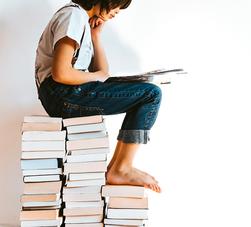 Young Reader on Stack of Books by Gaelle Marcel on Unsplash